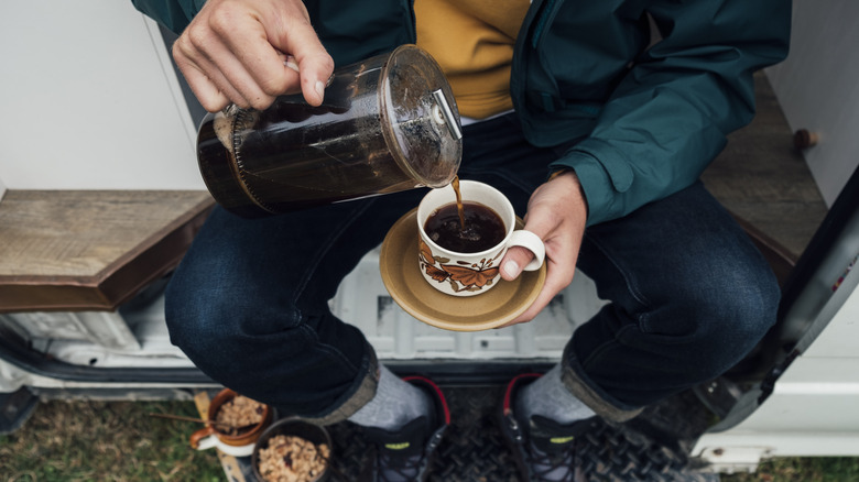 Man pouring cup of French press coffee