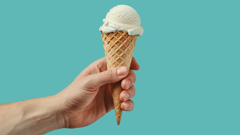 Hand holding vanilla ice cream cone