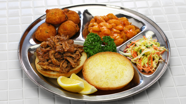 Lexington dip barbecue served alongside hushpuppies, beans, and slaw