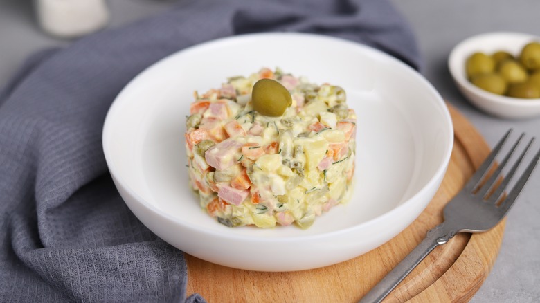 Russian potato salad in white bowl