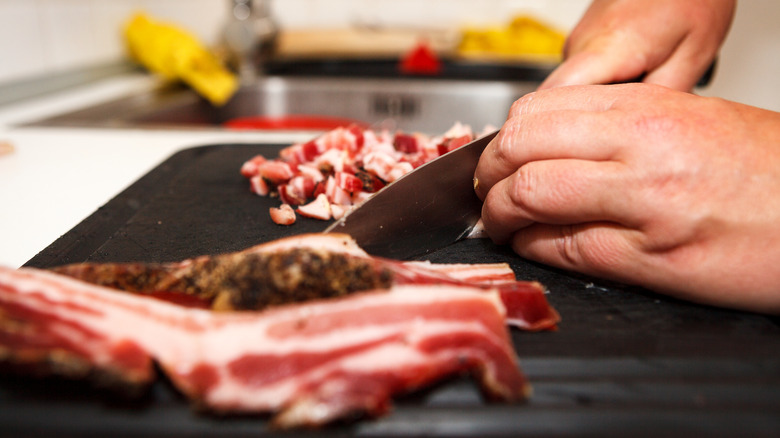 a person cutting bacon with a knife