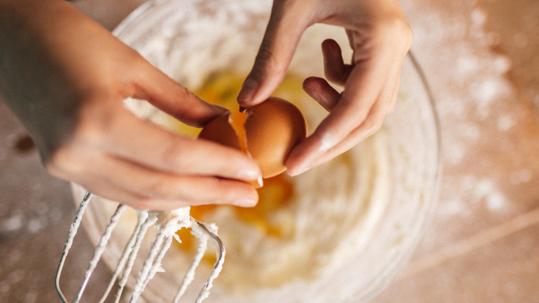 cracking egg into bowl of batter