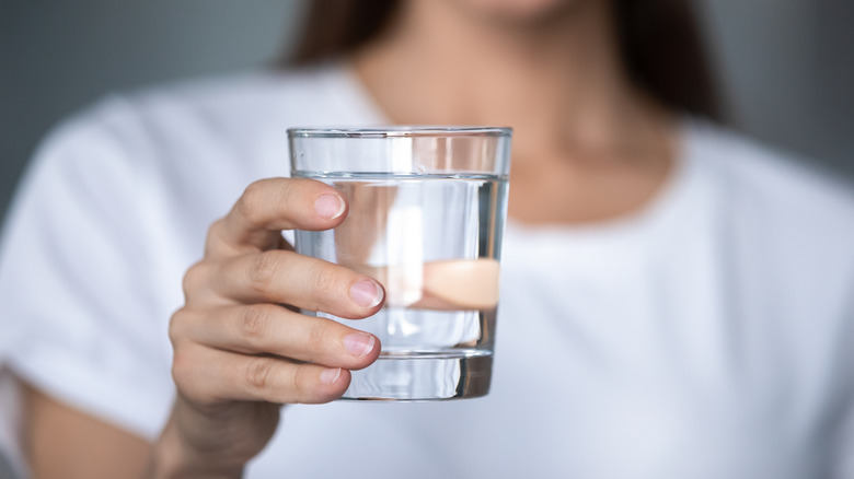 Woman holding glass of water