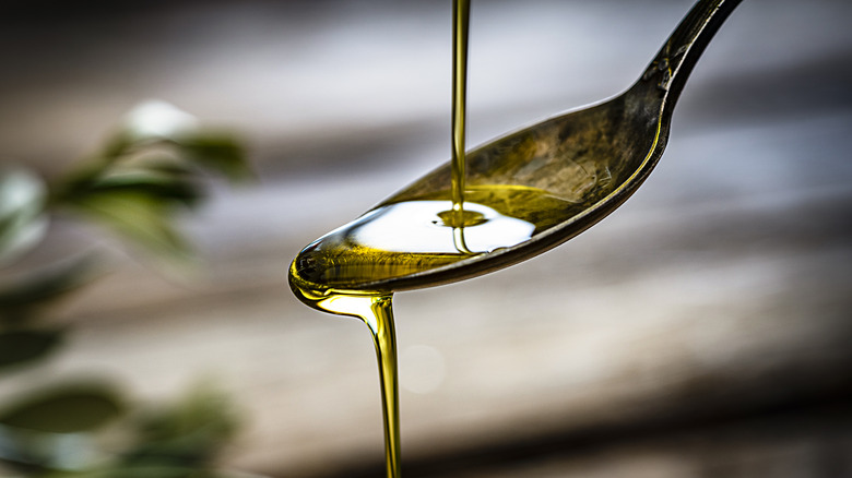 Olive oil pouring onto spoon