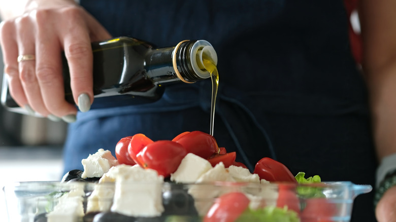 Person drizzling oil in a bowl