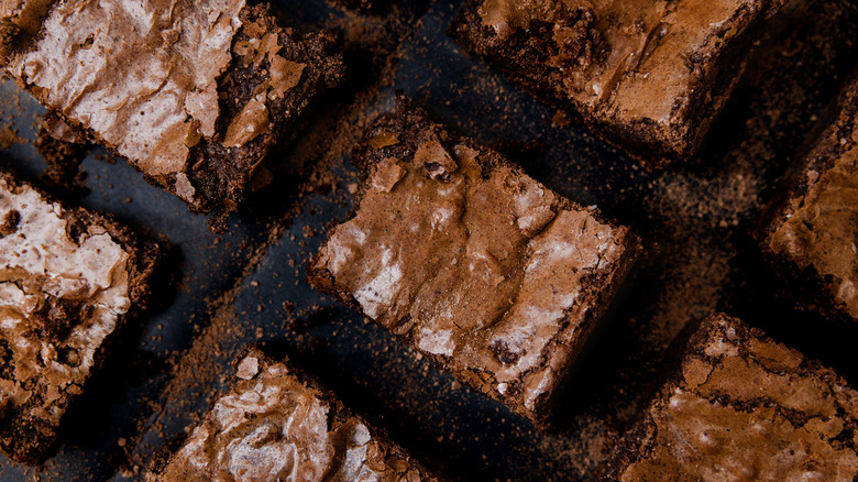 Multiple brownies cut into squares on a black surface