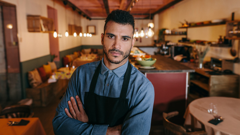 A waiter with a grumpy expression.