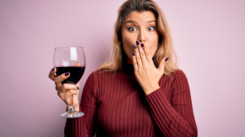woman shocked drinking wine