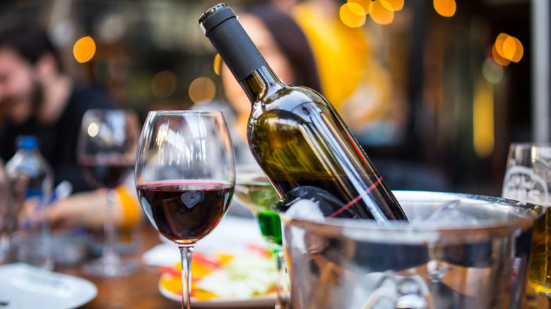 Bottle of chilled red wine next to glass