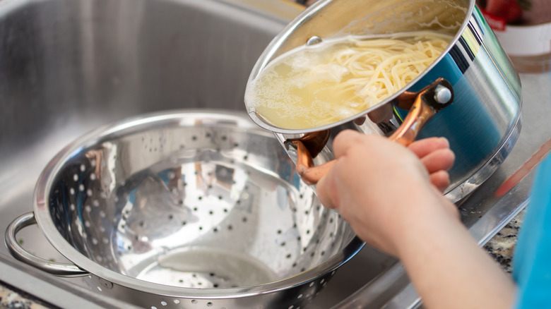 straining spaghetti into a colander