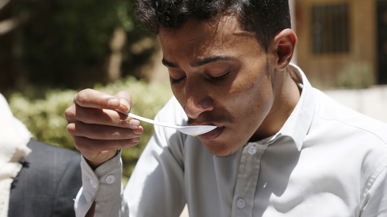 Man slurping coffee from spoon