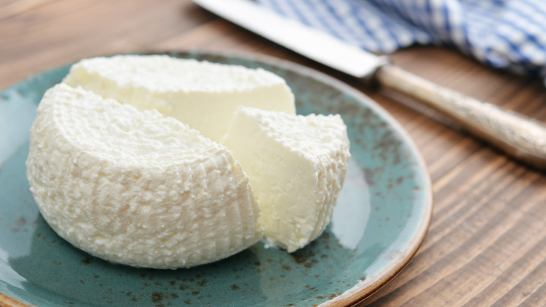 Fresh ricotta cheese on plate with knife