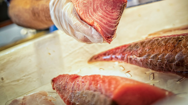 fish monger holding ahi steak