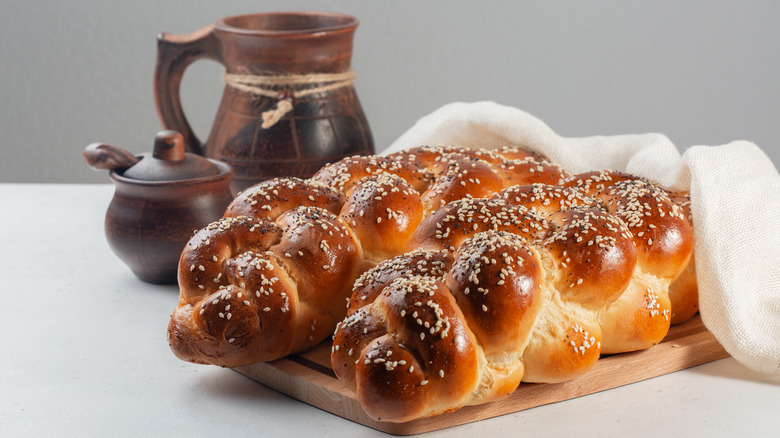 Two American-style challah with seeds, covered per Jewish tradition