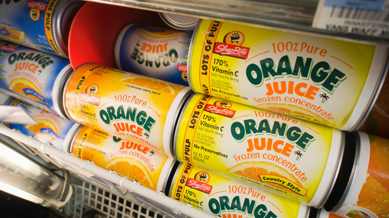 Generic frozen orange juice brands are stacked in a grocery store freezer
