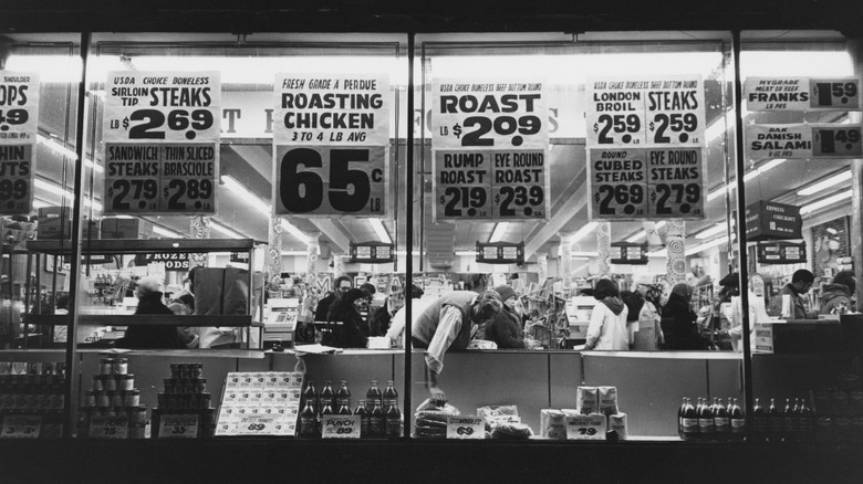 A 1980s supermarket window displays prices for various items