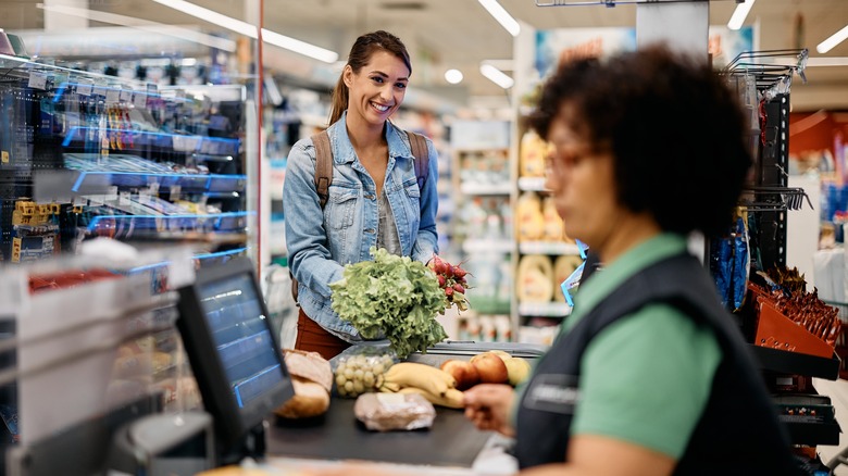 Woman paying at grocery checkout