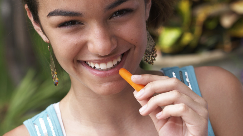 Woman eating baby carrot