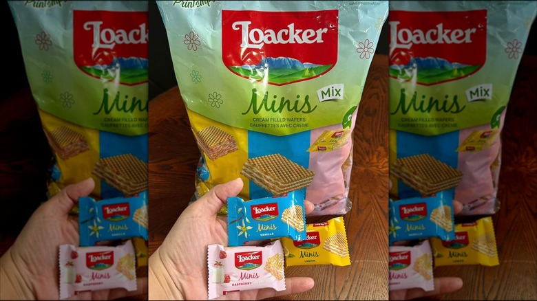 A hand holds out individually wrapped mini wafers in front of the bag.