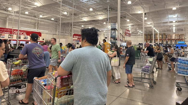 Many shoppers wait in the checkout line at a Costco.