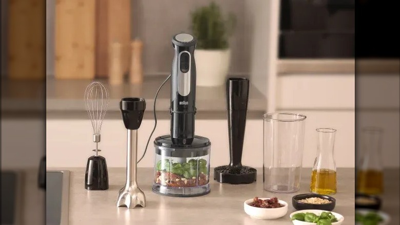 A Braun handheld blender with various attachments