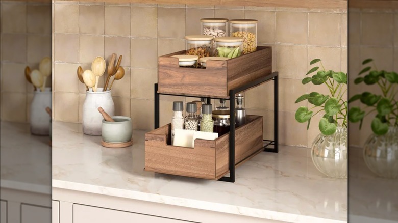 The Seville Classics 2-Tier Acacia Sliding Bin Organizer filled with spices