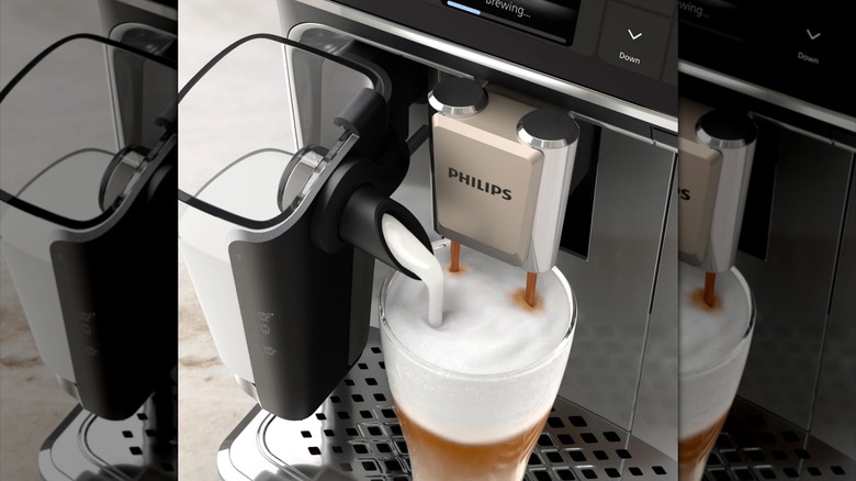 a Phillips coffeemaker pours milk and coffee into a glass