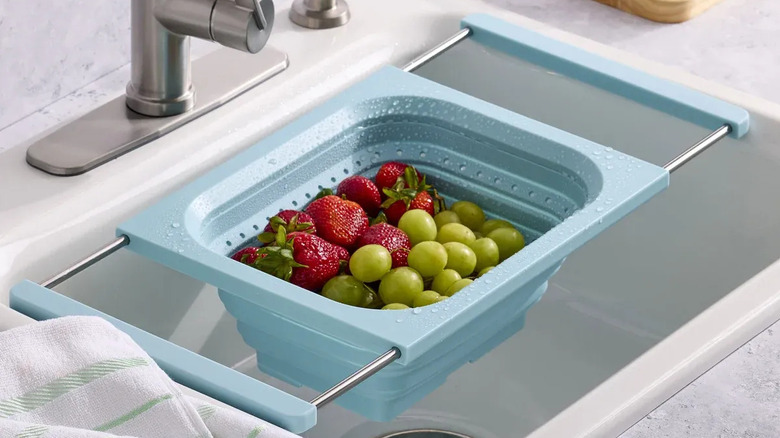 a pale blue colander propped in sink