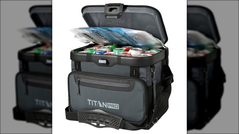 A Titan PRO by Arctic Zone cooler with the lid open, revealing beverage cans inside.