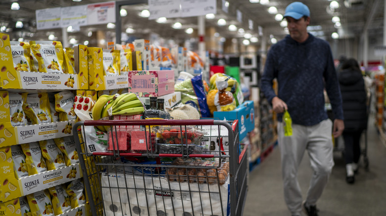 A shopper with a full cart in a Costco Warehouse store