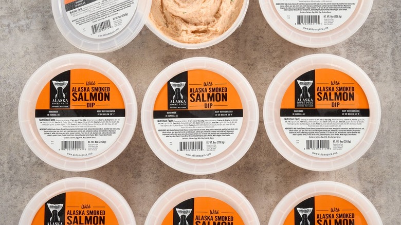 Tubs of salmon dip sit on a marbled surface.