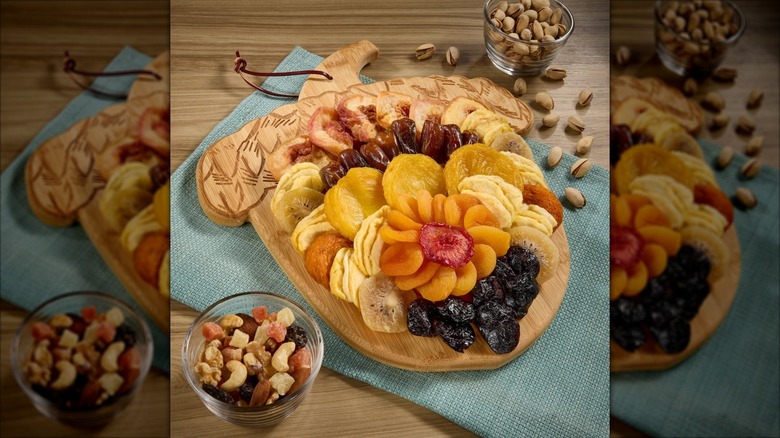 Dried fruits and nuts sit on an acorn-shaped board.