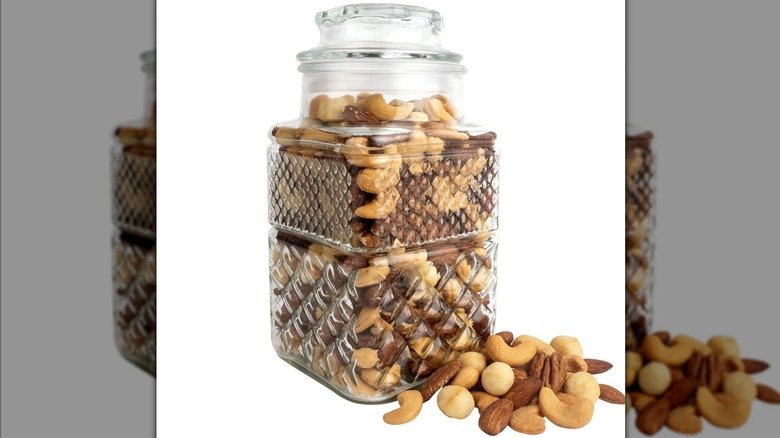 A jar of nuts sits against a white background.