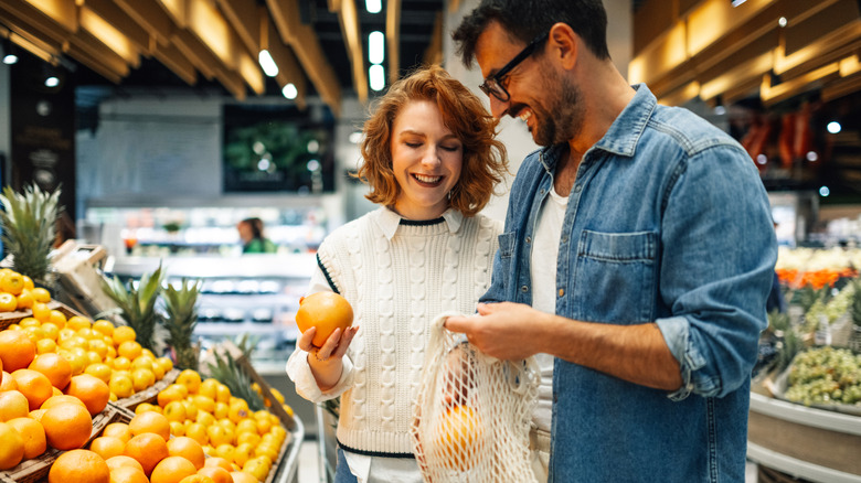 Couple selecting produce in a grocery store.
