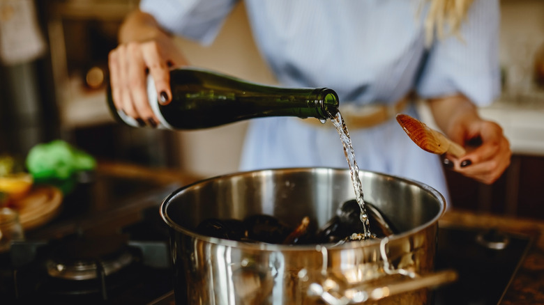 woman adding wine to soup saucer