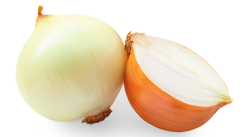 One peeled white onion and one half of an unpeeled onion.