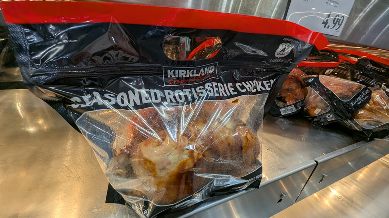 Bags of Costco's Seasoned Rotisserie Chickens under heat lamp