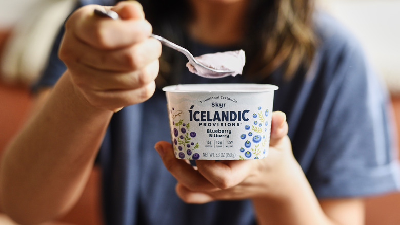 hands holding skyr and spoon