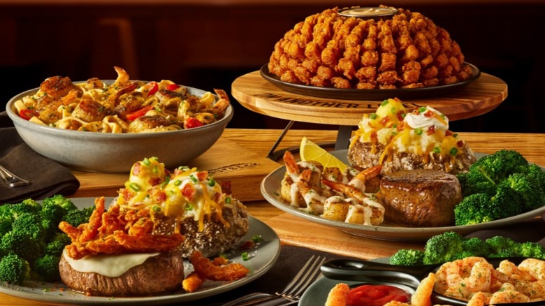 Two steak entrees from Outback Steakhouse with sides and a salad