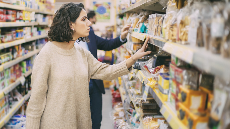 A shopper searching cookie brands at the grocery store.