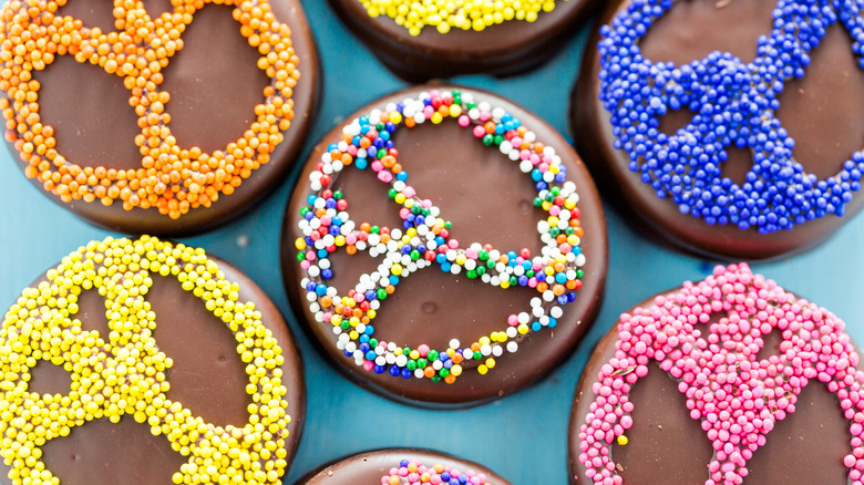 Chocolate-covered oreos decorated with some sprinkles in a peace sign.