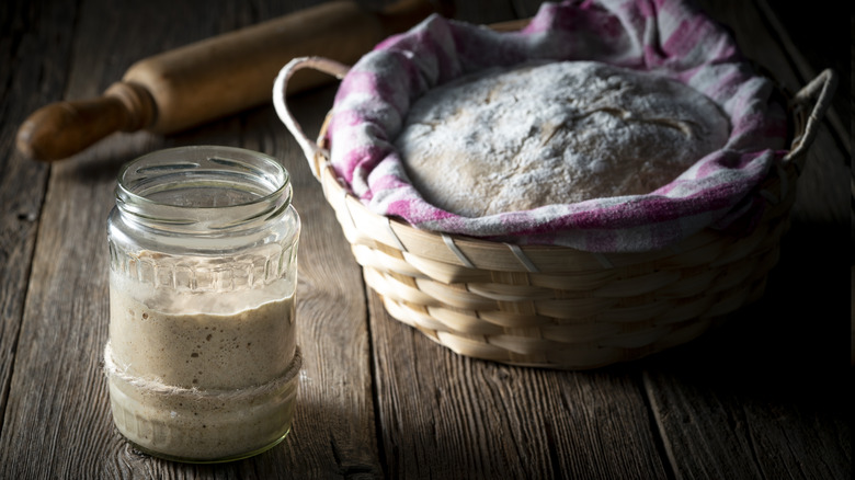 Sourdough dough starter in glass with homemade bread