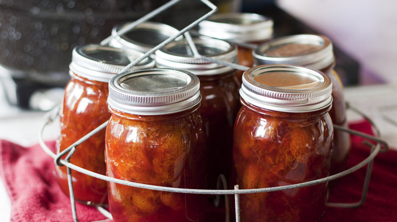Canning jars in metal insert just removed from boiling water