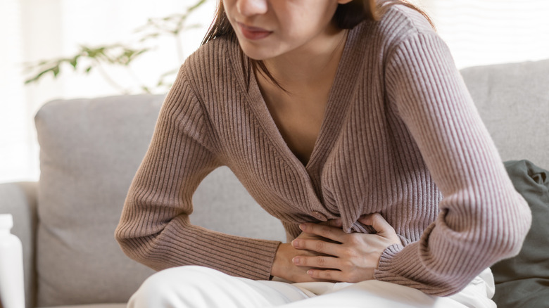 Person holding stomach in pain