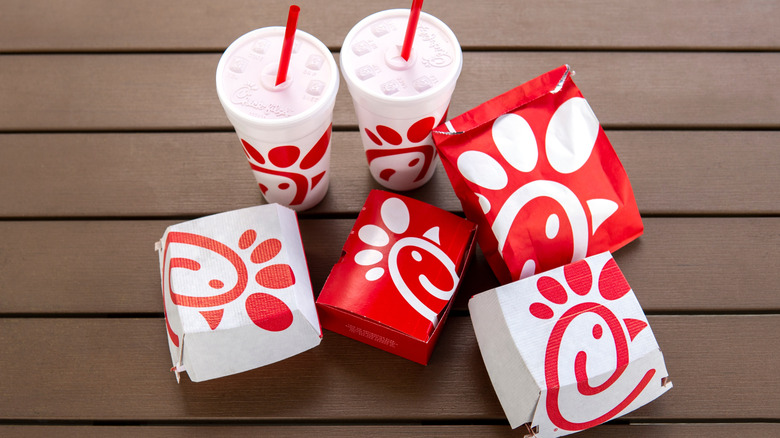 Chick-fil-A containers and beverages on brown background.
