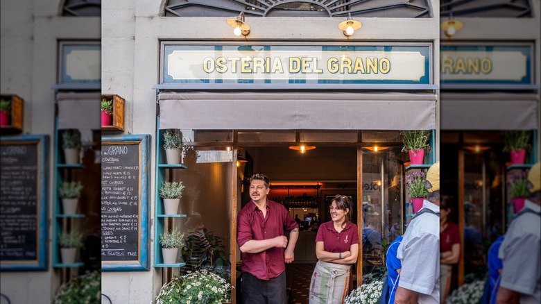 Two people in doorway of Italian osteria