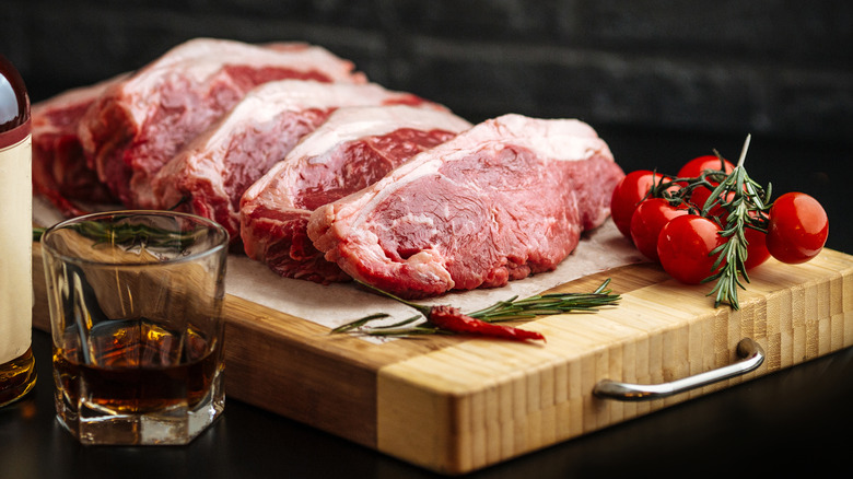Preparing raw steaks to cook with whiskey