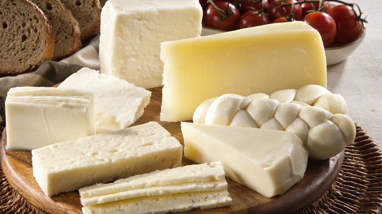 several types of cheese wedges on wooden platter