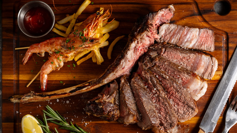 Steak and shrimp served on a wooden board