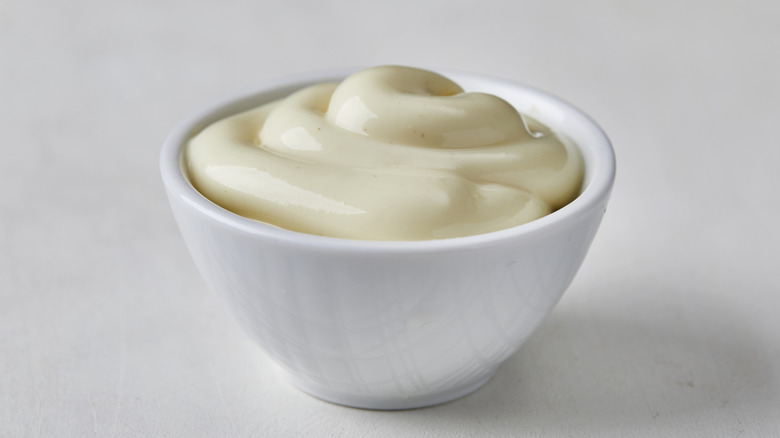 A bowl of mayonnaise sits on a white countertop